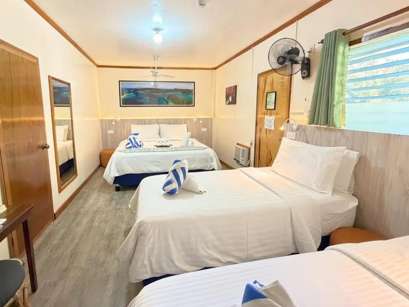 Chambre lumineuse avec lits jumeaux et décoration marine.