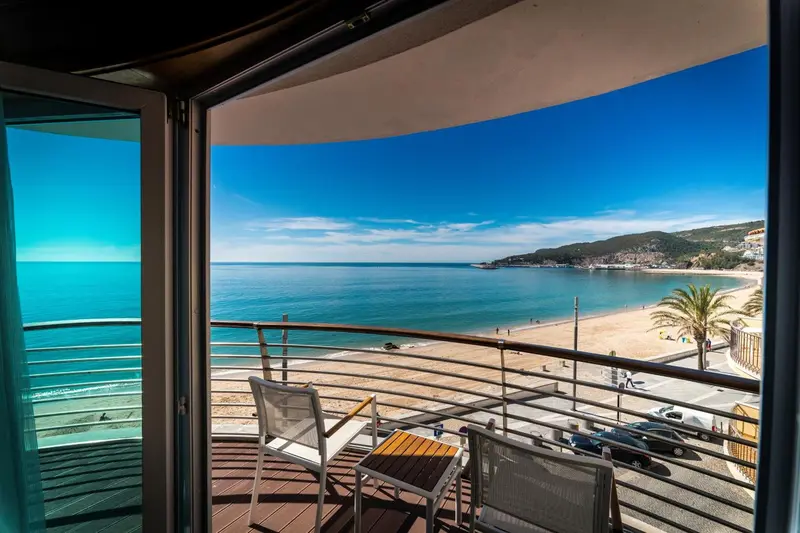 Vue sur la mer depuis une terrasse avec mobilier d'extérieur.