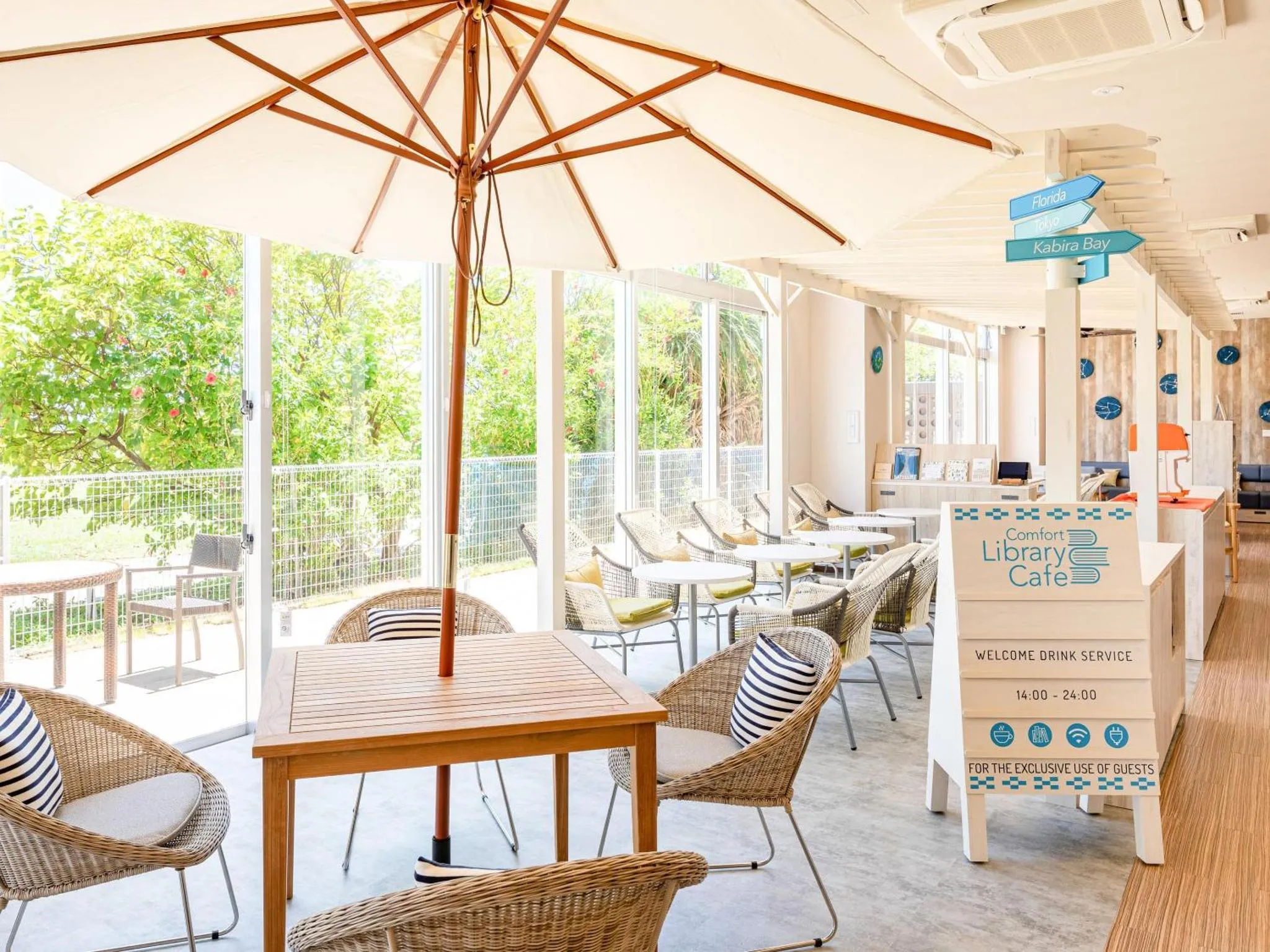 Une terrasse ombragée avec des tables et des chaises en osier.