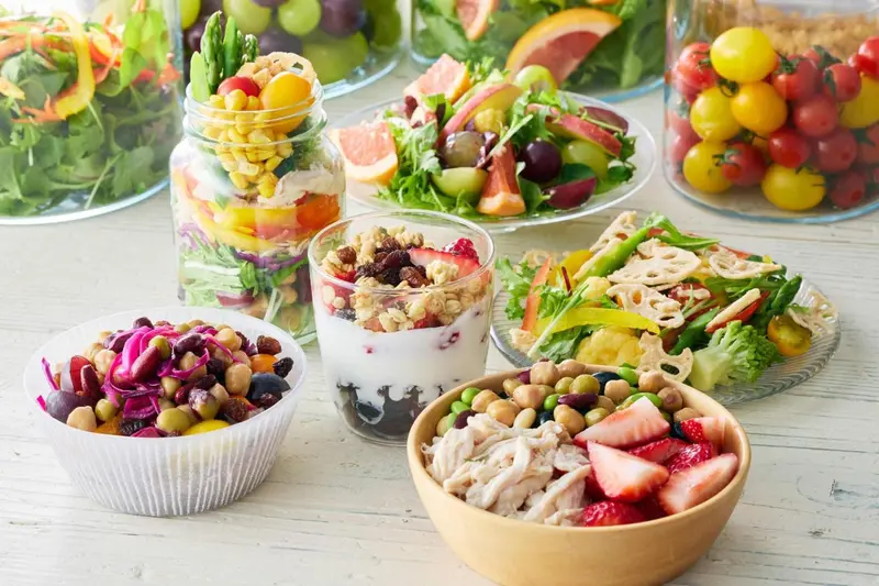 Assortiment de salades colorées et de plats légers présentés dans des récipients variés.
