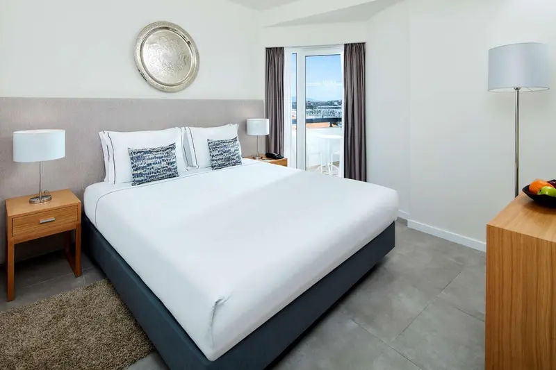 Une chambre lumineuse avec un grand lit et une vue sur la mer.