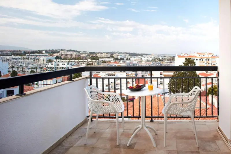Terrasse avec table et chaises donnant sur une vue urbaine.