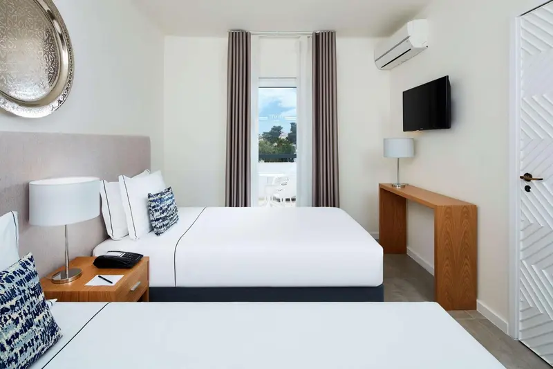 Une chambre lumineuse avec un grand lit et une décoration sobre.