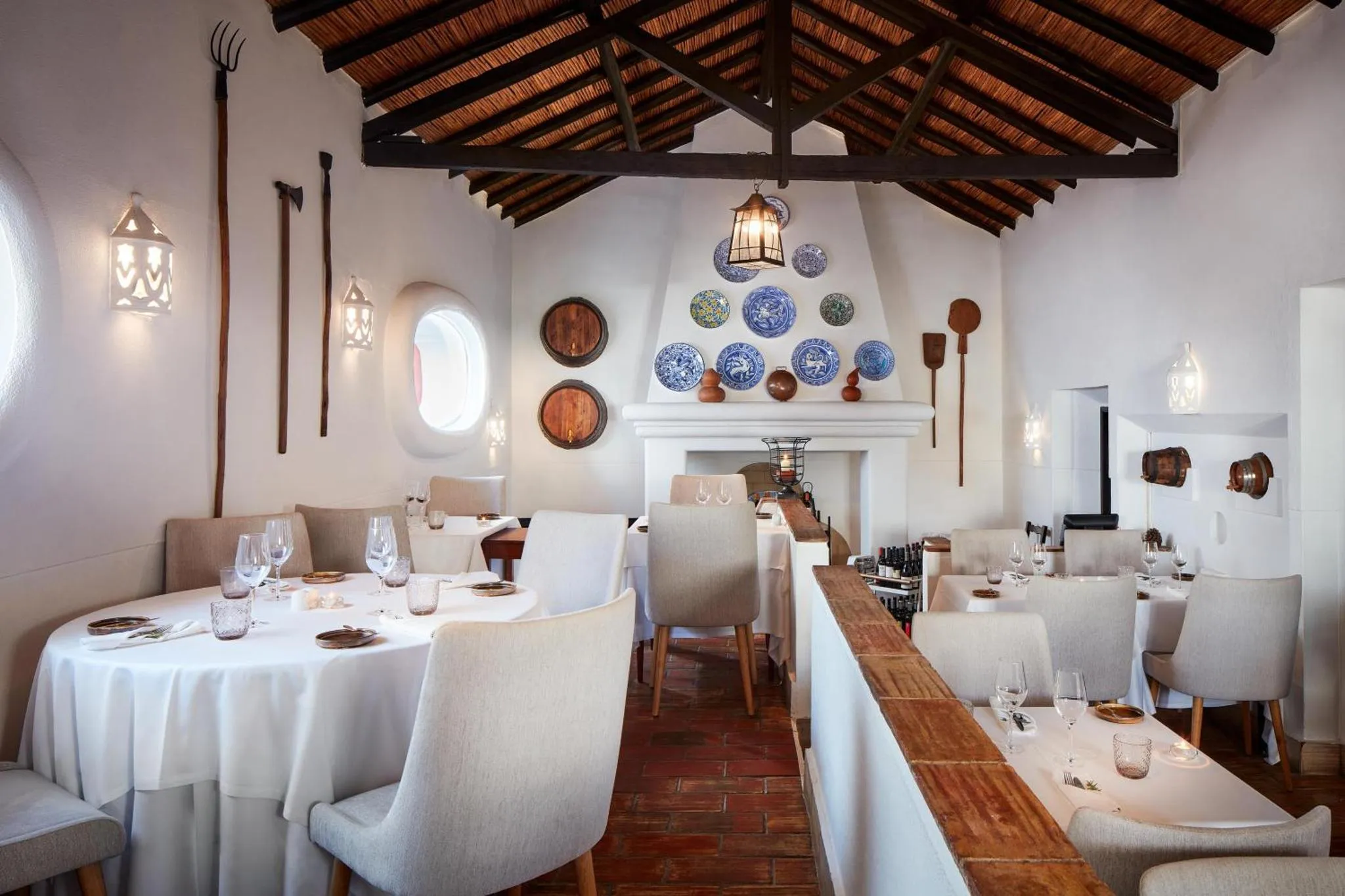 Une salle de restaurant lumineuse avec des tables nappées et une décoration murale.