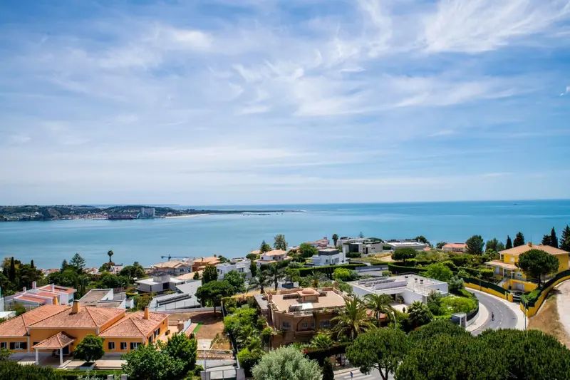 Vue aérienne d'une côte avec des villas et la mer en arrière-plan.
