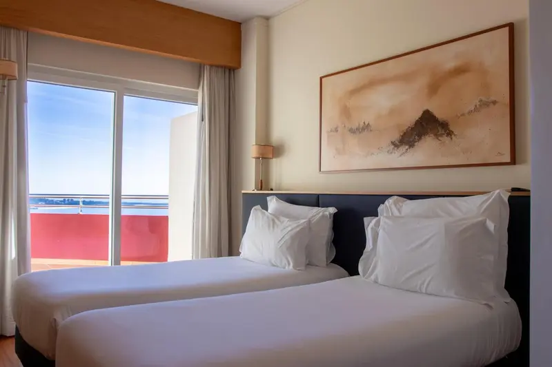 Une chambre lumineuse avec un grand lit et une vue sur la mer.