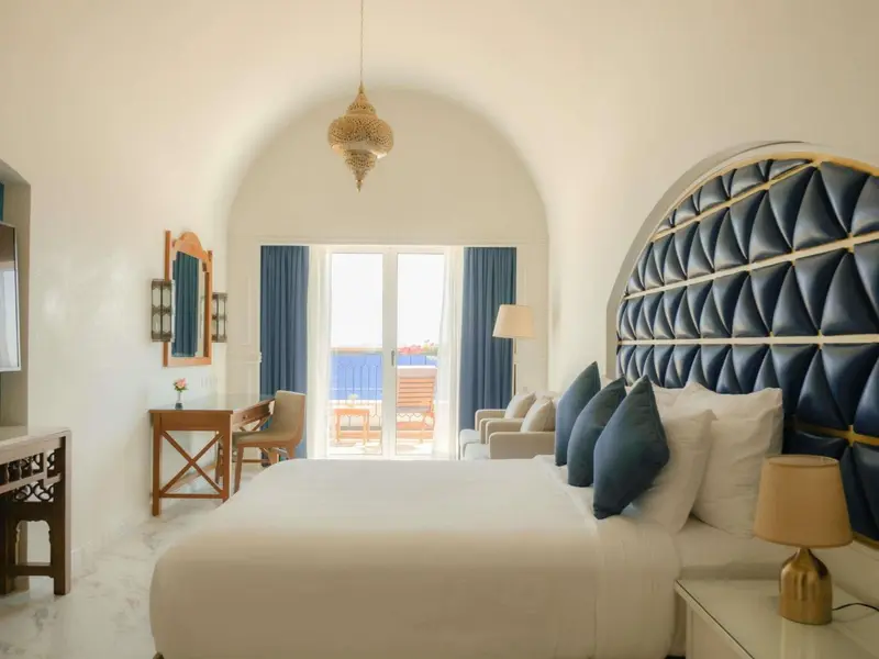 Une chambre lumineuse avec un grand lit et un décor sobre.