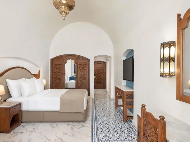 Une chambre lumineuse avec un grand lit et un décor traditionnel.