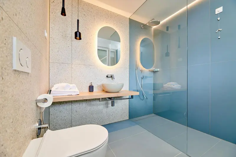 Une salle de bain moderne avec douche à l'italienne et lavabo sur console.