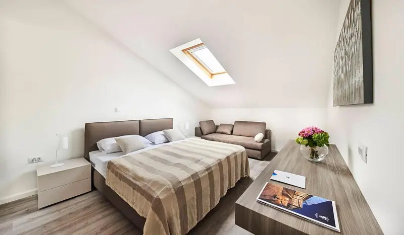 Une chambre lumineuse avec un lit et un canapé.