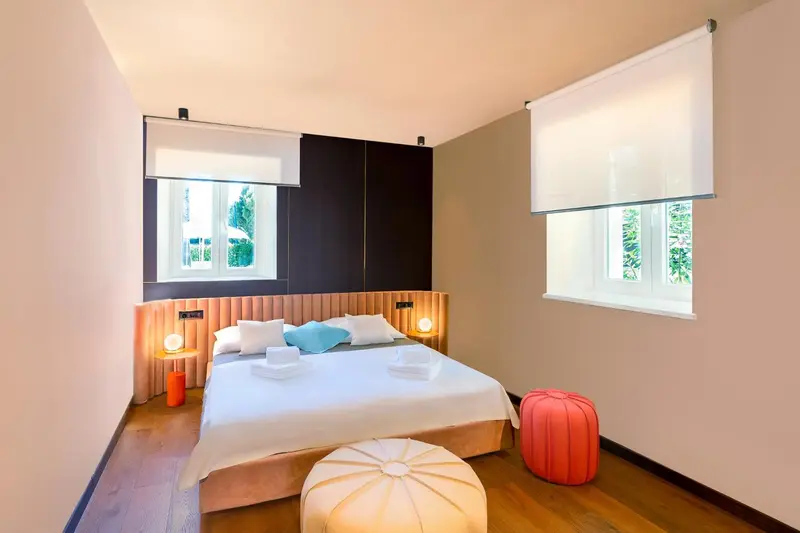 Une chambre lumineuse avec un grand lit et des oreillers décorés.