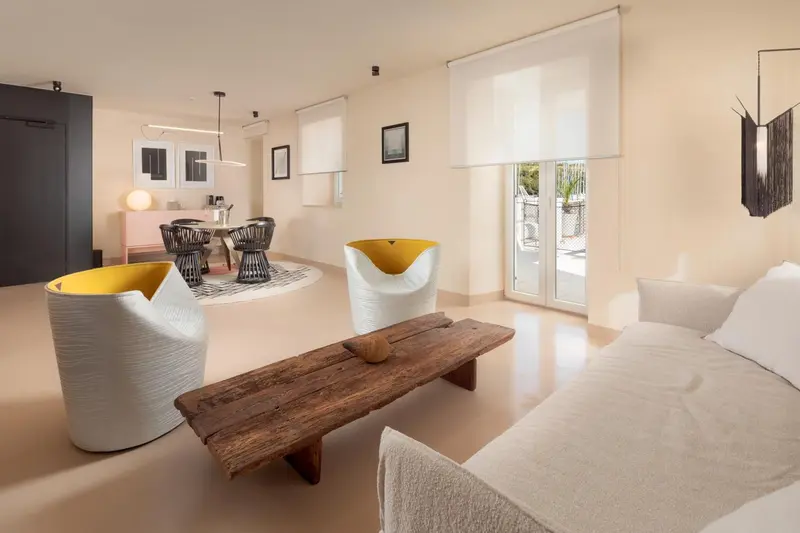 Espace de vie intérieur lumineux avec mobilier design et accès à une terrasse.