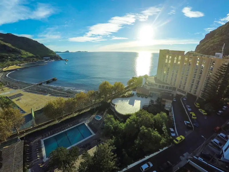Vue aérienne d'un hôtel avec piscine et accès à la plage.