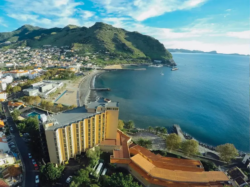 Vue aérienne d'une ville côtière avec des bâtiments et une plage.