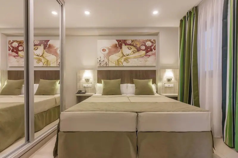 Une chambre d'hôtel avec un grand lit et des miroirs.