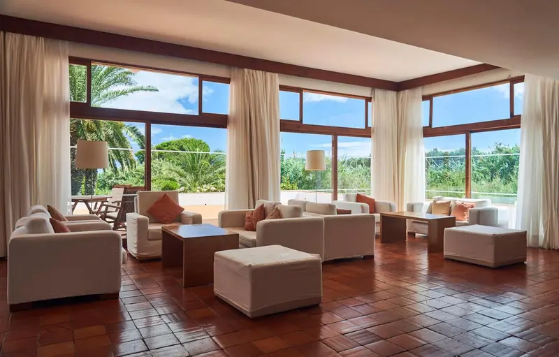 Espace de détente lumineux avec canapés et larges baies vitrées.
