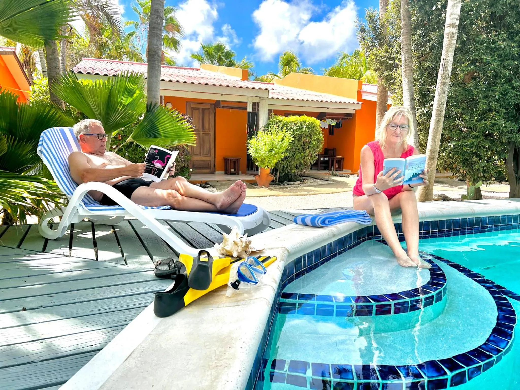 Deux personnes se détendent au bord d'une piscine ensoleillée.