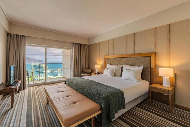 Une chambre lumineuse avec un grand lit et une vue sur la mer.