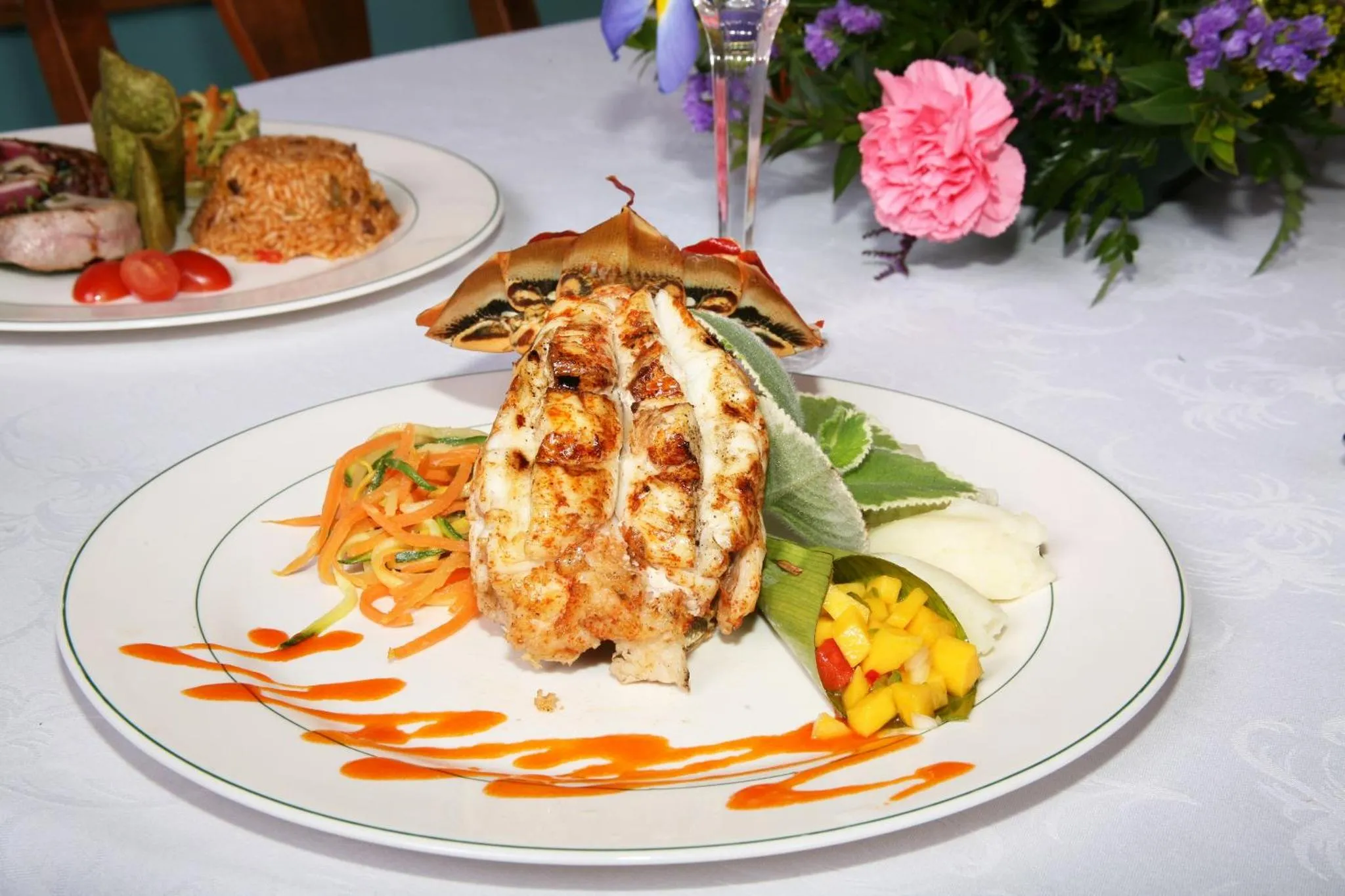 Assiettes de plats de poisson décorés avec des légumes et des sauces.