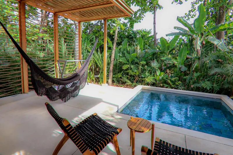Espace de détente extérieur avec hamac et petite piscine.