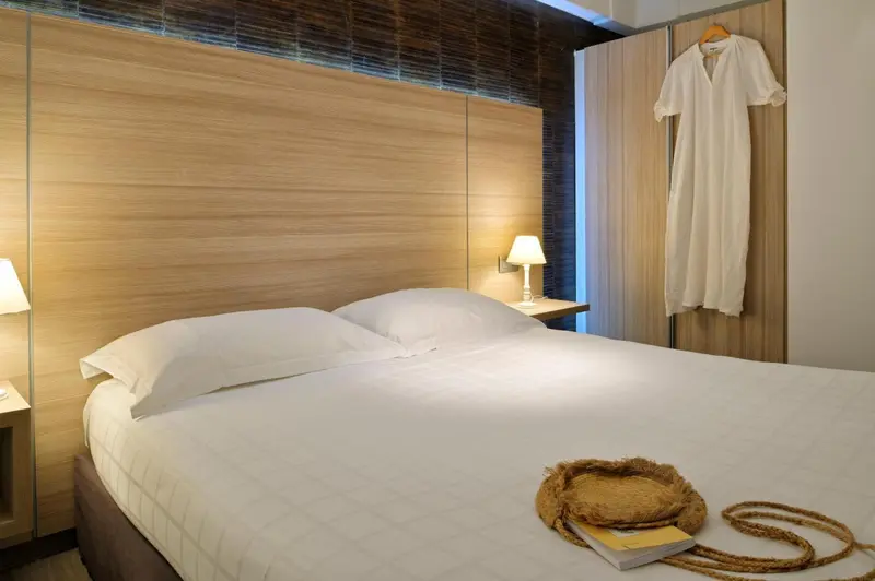 Une chambre lumineuse avec un grand lit et une décoration sobre.