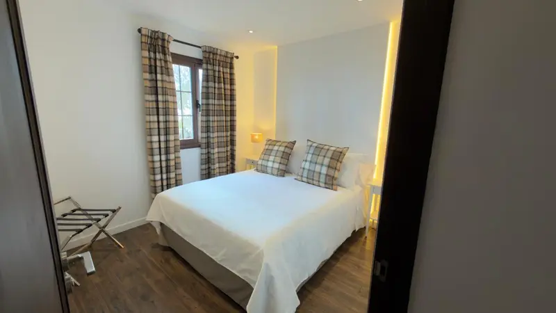 Une chambre lumineuse avec un grand lit recouvert de draps blancs.