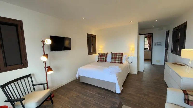 Une chambre lumineuse avec un grand lit et un coin salon.