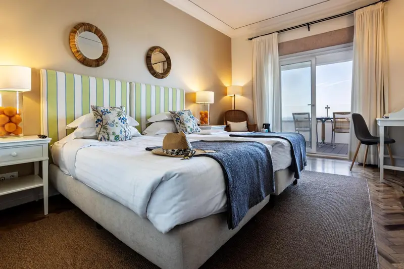 Une chambre lumineuse avec un grand lit et un accès à une terrasse.