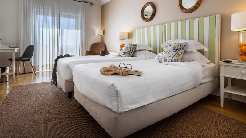 Une chambre lumineuse avec deux lits simples et une décoration soignée.