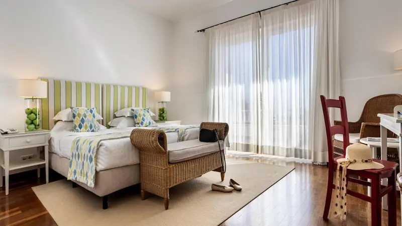 Une chambre lumineuse avec un grand lit et un coin salon.