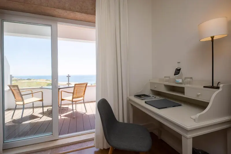 Une chambre lumineuse s'ouvre sur une terrasse avec vue sur la mer.