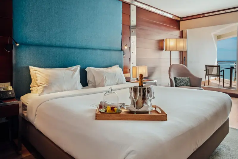 Une chambre d'hôtel avec un grand lit et une bouteille de champagne.