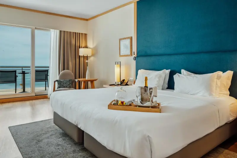 Une chambre lumineuse avec un grand lit et une vue sur la mer.