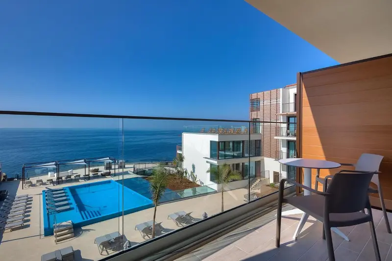 Vue sur la mer depuis un balcon avec mobilier d'extérieur.