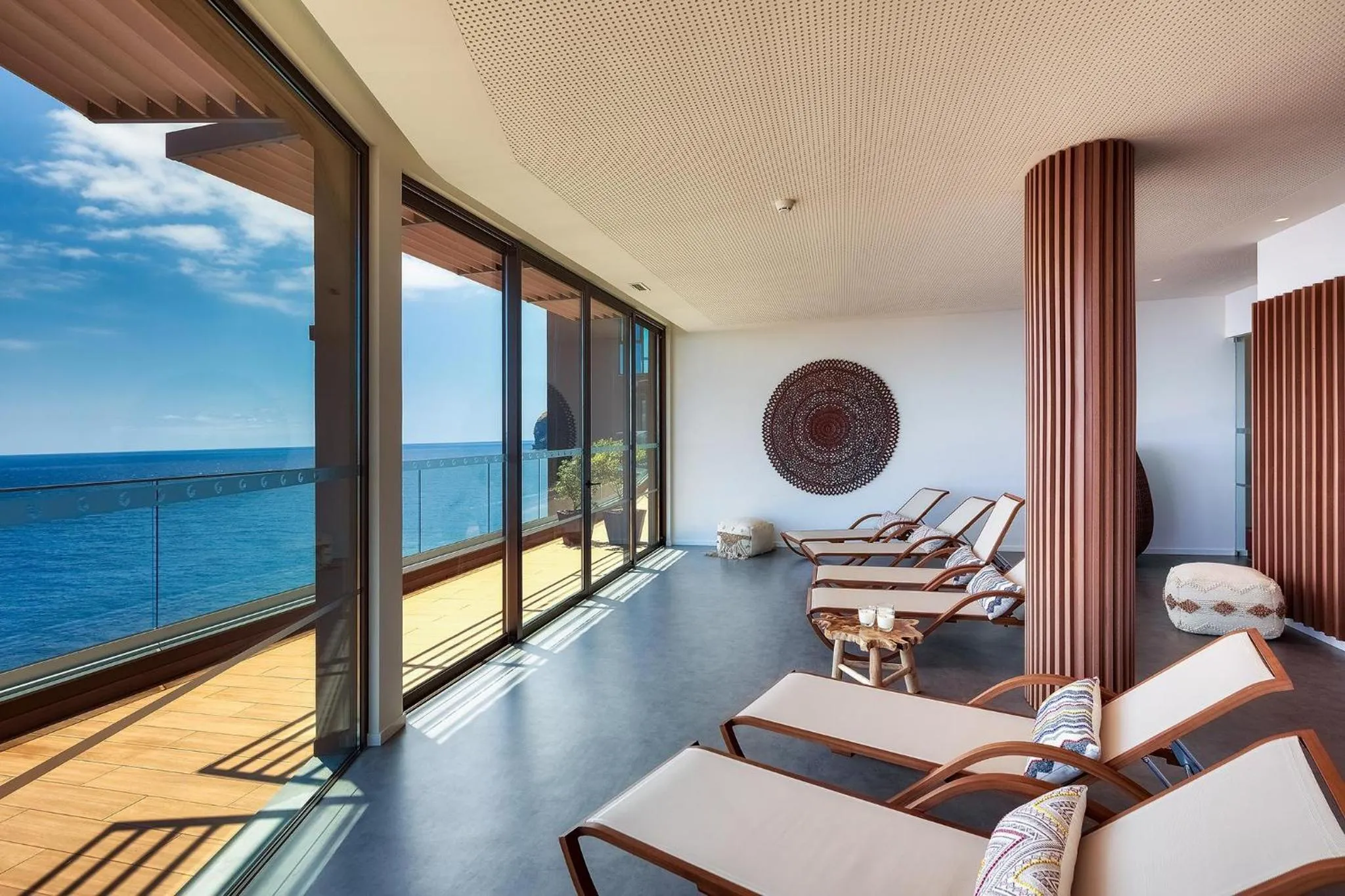 Espace de détente avec transats face à la mer.