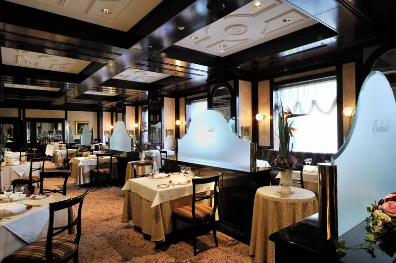 Une salle de restaurant élégante avec des tables dressées et une décoration soignée.
