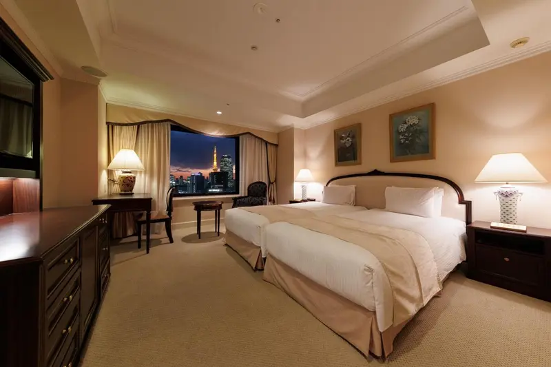 Chambre d'hôtel avec un grand lit et une vue sur la ville la nuit.