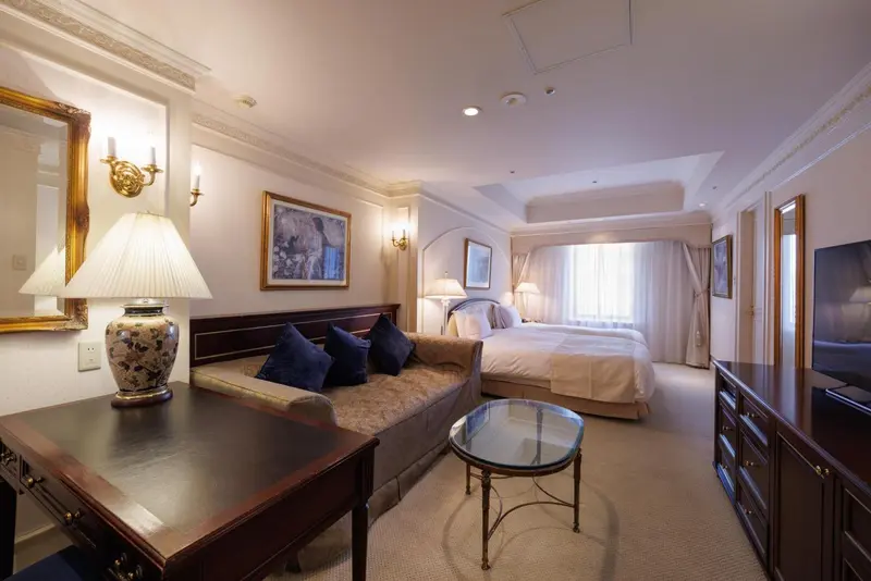 Chambre lumineuse avec un lit et un coin salon.
