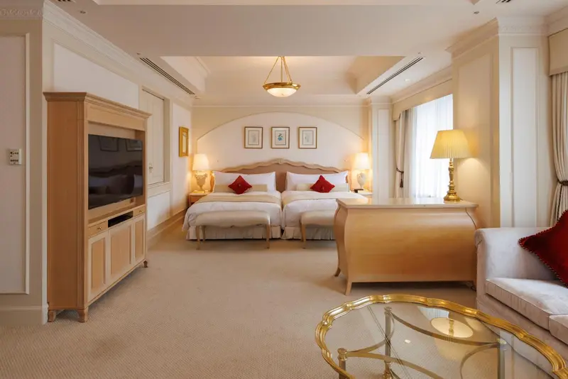 Une chambre lumineuse avec deux lits simples et un coin salon.