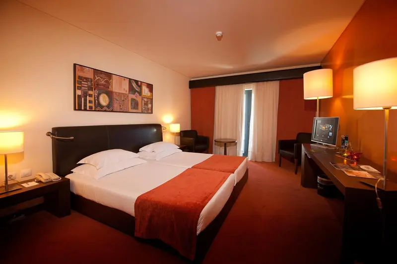 Chambre d'hôtel avec un grand lit et une décoration chaleureuse.