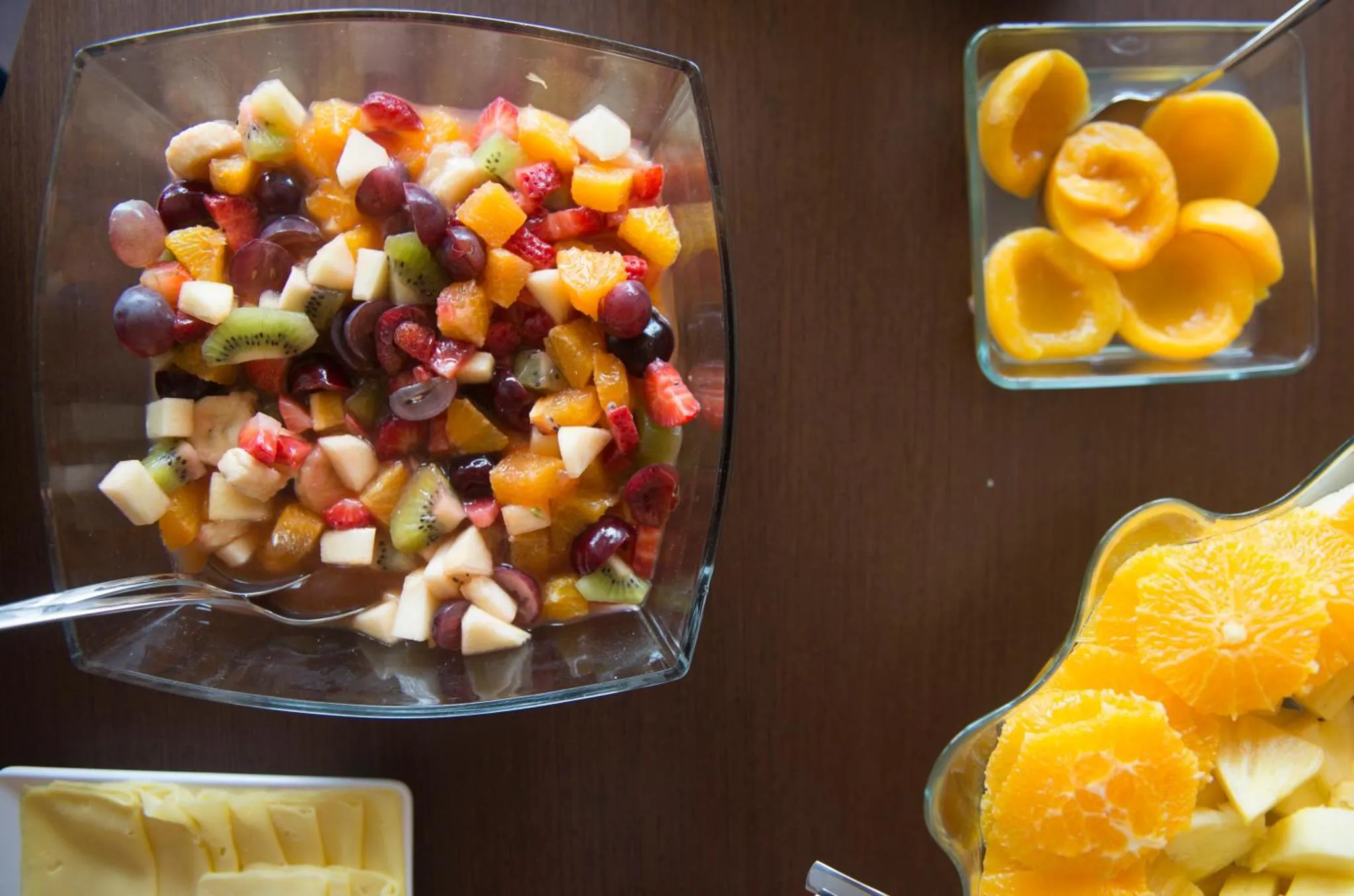 Salade de fruits frais présentée dans des coupes en verre sur une table en bois.
