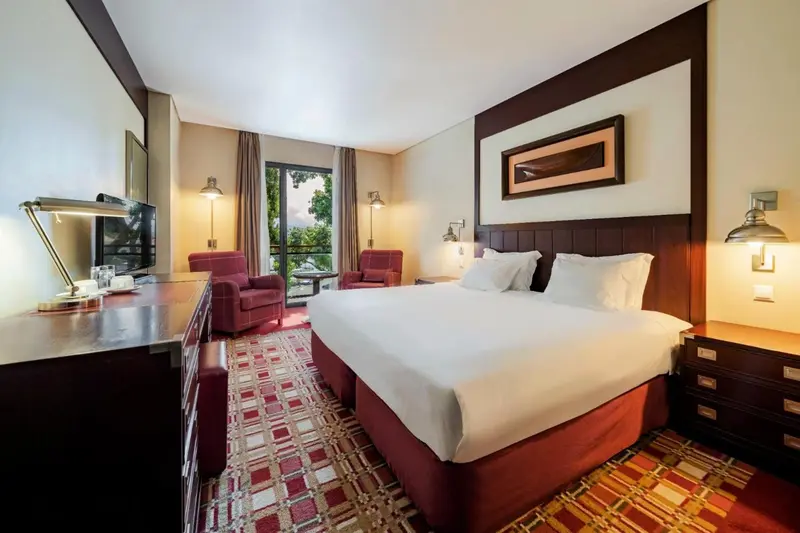 Chambre d'hôtel lumineuse avec un grand lit et un coin salon.