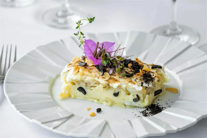 Une part de dessert crémeux est présentée sur une assiette blanche décorée.