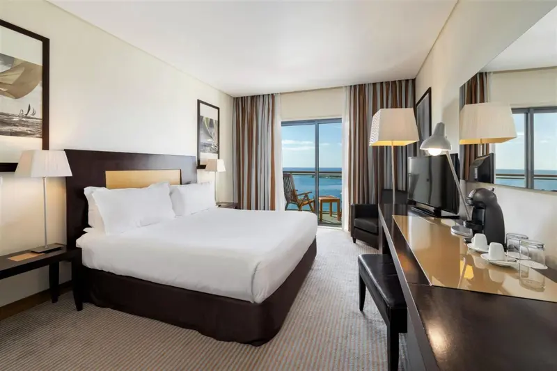 Une chambre lumineuse avec un grand lit et une vue sur la mer.