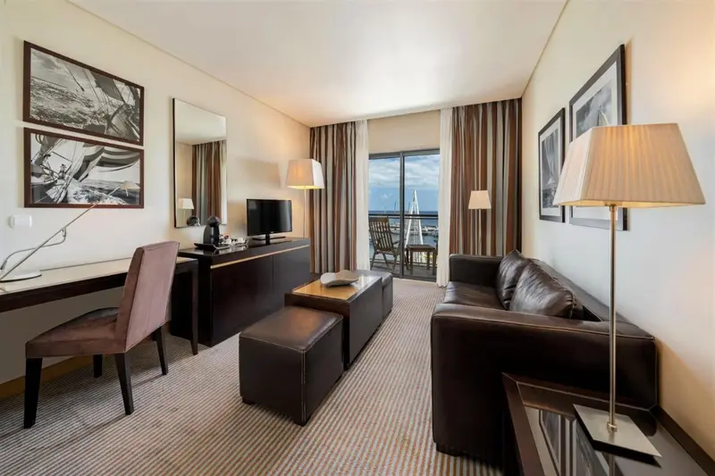 Un salon moderne avec canapé, table basse et bureau près d'une fenêtre.