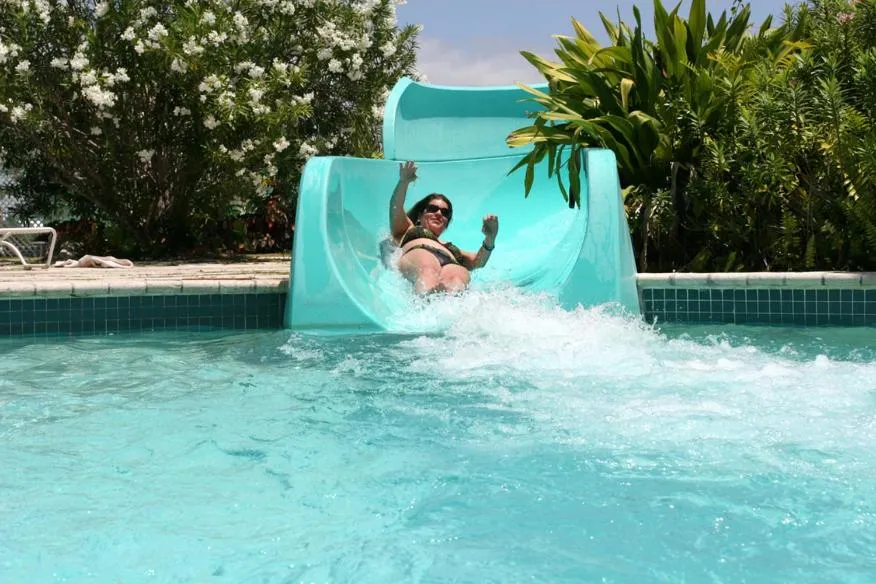 Une personne descend un toboggan aquatique dans une piscine.