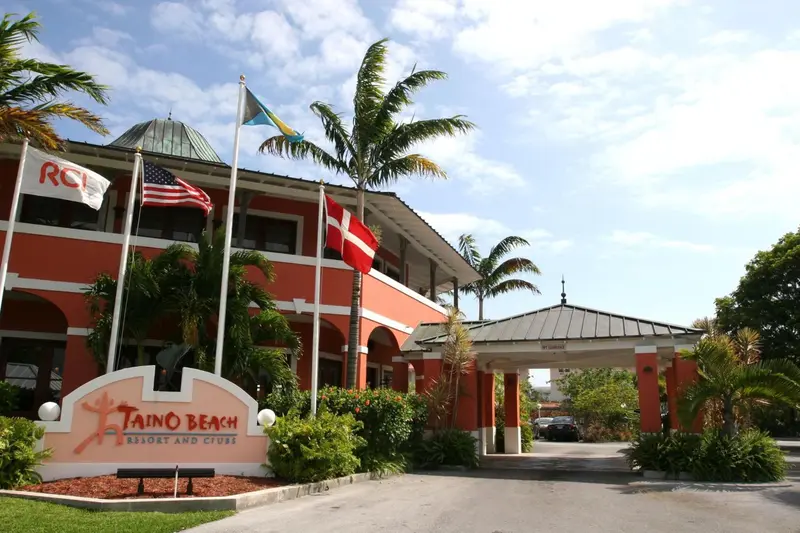 Bâtiment orange à l'entrée d'un complexe hôtelier tropical.