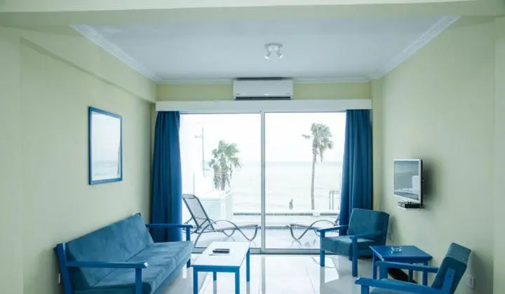 Un espace de séjour lumineux avec canapés et vue sur la mer.