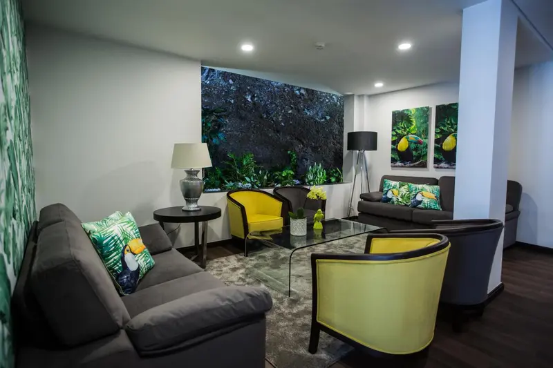 Un espace de détente intérieur avec canapés et fauteuils colorés.