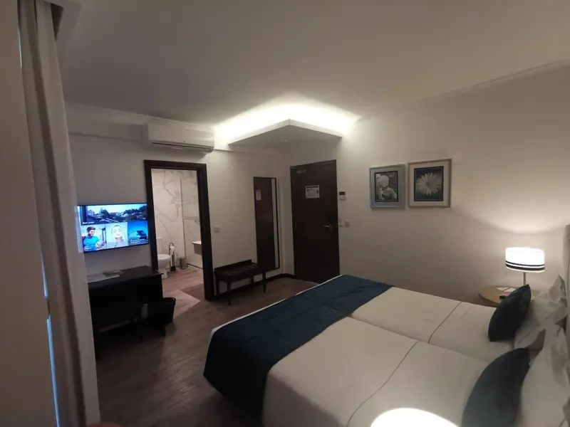 Une chambre lumineuse avec un grand lit et un téléviseur mural.